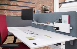 moderner Schreibtisch mit einem grauen Trenner und Bildschirmarm