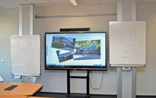 Smartboard und Whiteboards in einem Klassenzimmer vor dem Lehrerpult