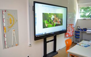 Smartboard in einem Klassenzimmer vor dem Lehrerpult