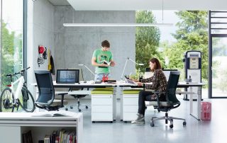 Moderner und frischer Arbeitsbereich mit einer Schreibtischgruppe und einer großen Deckenleuchte