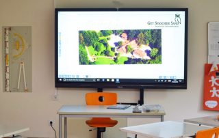 Smart-board in einem Klassenzimmer mit ergonomischen Stühlen